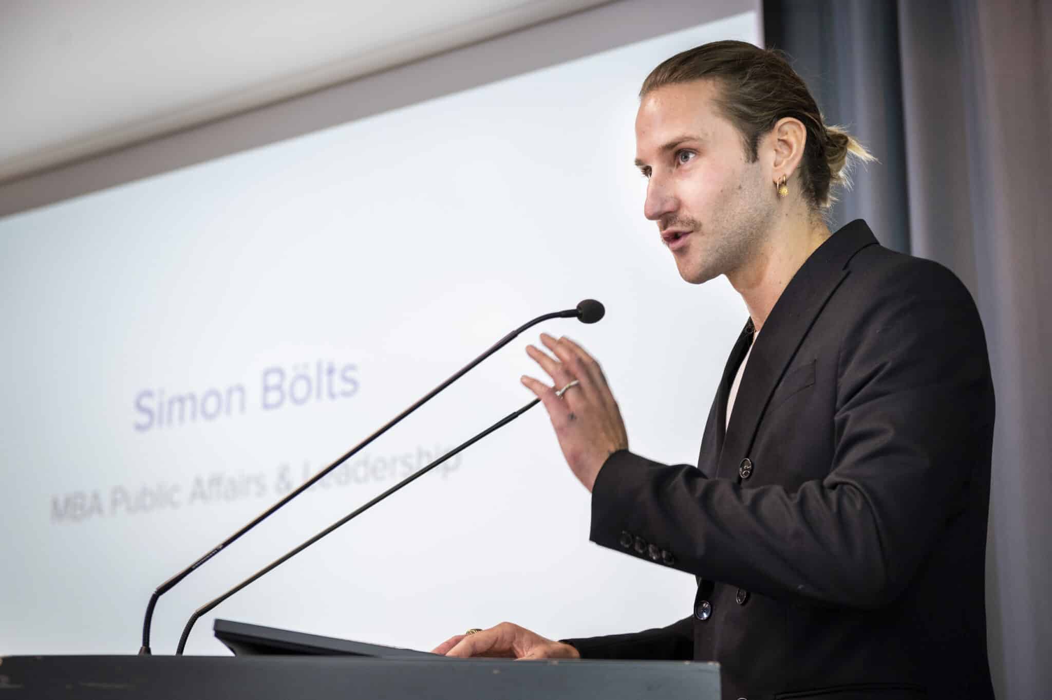 "Unmute yourself": Simon Bölts bei seiner Rede als Kurssprecher der MBAs Public Affairs und Communication. (Foto: Sebastian Höhn)